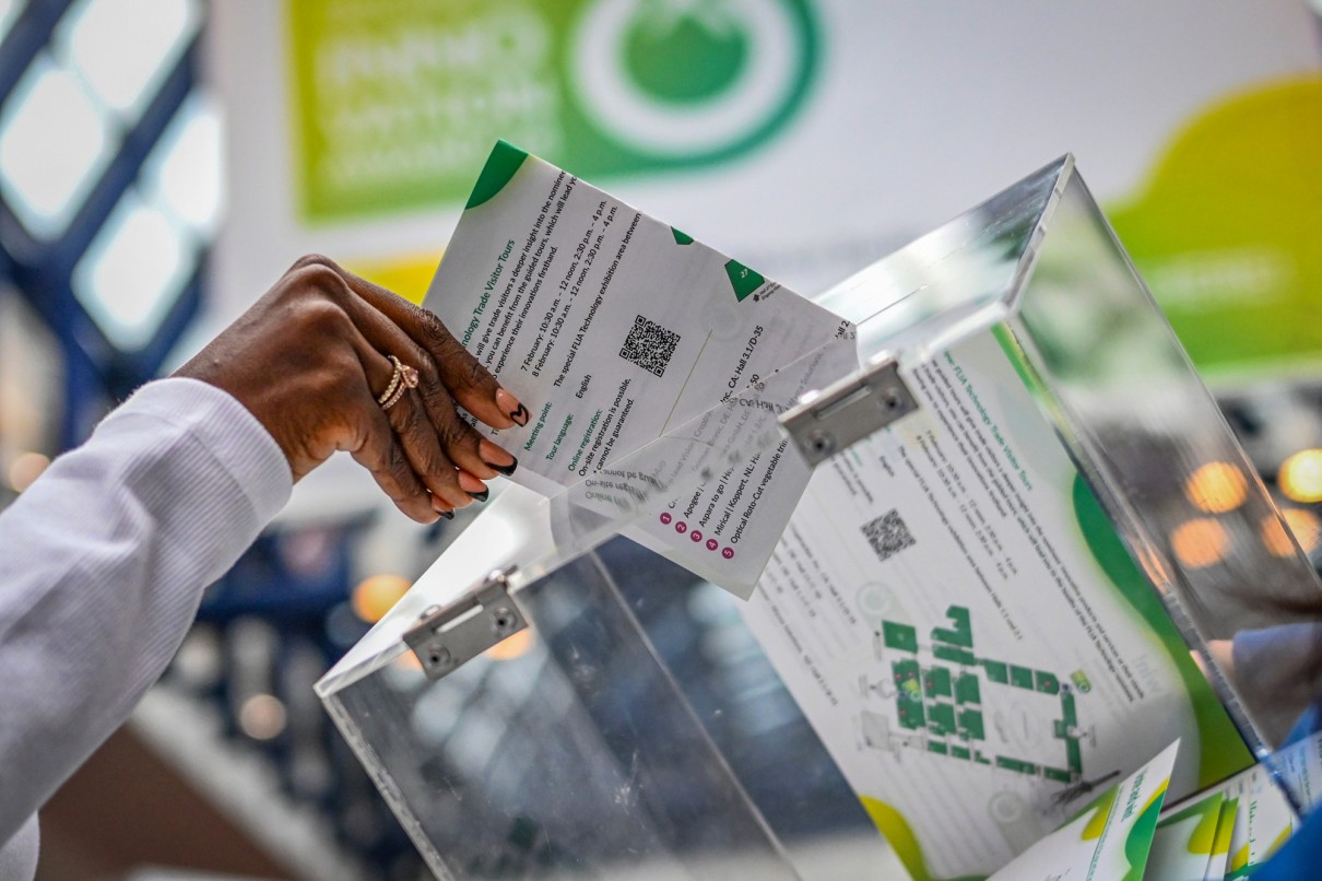 A woman's hand puts a note in a box with ballot papers, in which trade visitors vote for FLIA and FLIA Technology 2025.