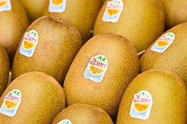 Close-up of yellow-fleshed kiwis with 'Zespri' brand stickers indicating the variety and origin of the fruits.