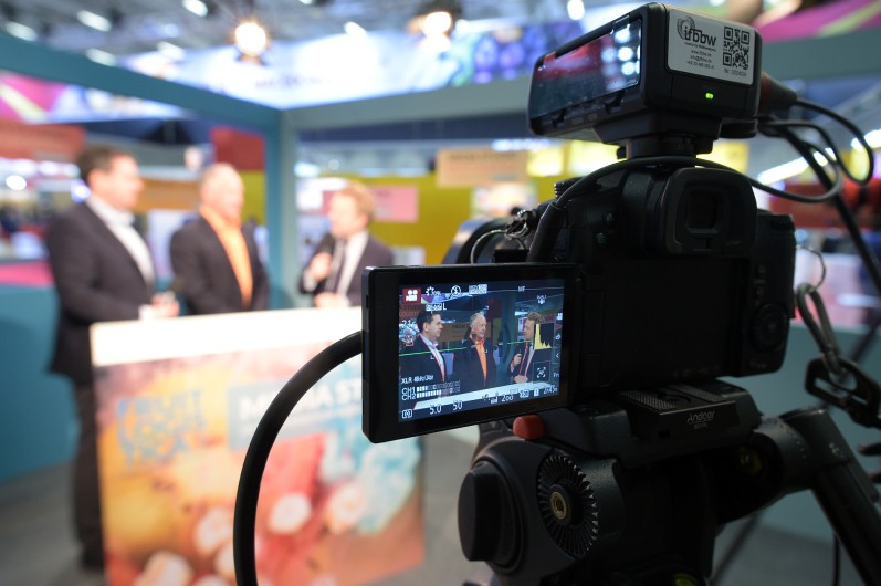 Image of a camera filming a press conference, as you requested.